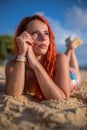 Beautiful girl with red hair posing on the beach. Sunset. Royalty Free Stock Photo