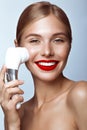 Beautiful girl with red lips and classic makeup with massage brush in hand. Beauty face.
