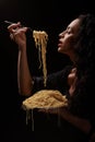 A beautiful girl eats with a fork spaghetti with red lips.