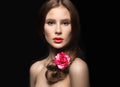 Beautiful girl with red lips and a rose in her hair. Beauty face. Royalty Free Stock Photo