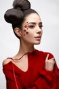 Beautiful girl in a red shirt and shiny hearts on her cheek. Model with a bow on her head and Nude makeup Royalty Free Stock Photo