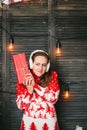 Beautiful girl in a red sweater wondering what inside christmas box - christmas and new year concept