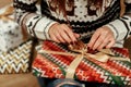Beautiful girl in reindeer winter sweater unwrapping christmas p
