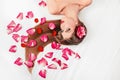 Beautiful girl relaxarea ,lying among rose petals Royalty Free Stock Photo