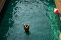 Beautiful girl relaxes in the swimming pool in sunny day Royalty Free Stock Photo