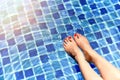 Beautiful girl relaxing in swimming pool, Legs of woman in water. Royalty Free Stock Photo