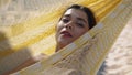 Beautiful girl resting hammock in bikini closeup. Carefree woman looking camera