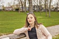 Beautiful girl resting on a park bench .