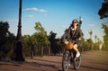 Beautiful girl ride a cruiser bicycle with flowers in basket Royalty Free Stock Photo