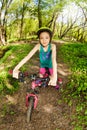 Beautiful girl riding her bike on the forest trail Royalty Free Stock Photo