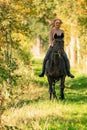 Beautiful girl riding a horse riding without a saddle in a autumn forest Royalty Free Stock Photo