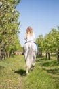 Beautiful girl riding a horse on a white horse in the garden Royalty Free Stock Photo