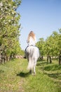 Beautiful girl riding a horse on a white horse in the garden Royalty Free Stock Photo