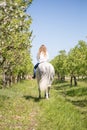 Beautiful girl riding a horse on a white horse in the garden Royalty Free Stock Photo