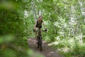 Beautiful girl is riding a mountain bike through the woods on a Royalty Free Stock Photo