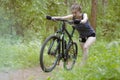 Beautiful girl is riding a mountain bike through the woods on a Royalty Free Stock Photo