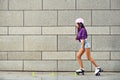 Beautiful girl rollerblading on the urban grey background in a park Royalty Free Stock Photo