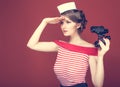 Beautiful girl sailor with a vintage binoculars and looks into the distance