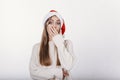 Beautiful girl in santa hat covering her mouth by hand Royalty Free Stock Photo