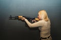 A beautiful girl shoots from an ak 47 carbine in a shooting range Royalty Free Stock Photo