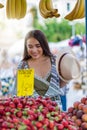 Beautiful girl shops at the market fresh fruit