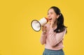 Asian woman screaming while holding megaphone with two hands making announcement Royalty Free Stock Photo