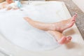 Beautiful girl showering and washing legs in bathtub.