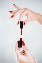 Beautiful girl showing red manicure nails. red nail polish bottle on white background. Stylish trendy female manicure. Royalty Free Stock Photo