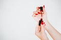 Beautiful girl showing red manicure nails. red nail polish bottle on white background. Stylish trendy female manicure. Royalty Free Stock Photo
