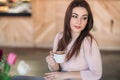 Beautiful girl sitting in cafe and drinking cappuccino