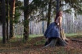 Beautiful girl sits on big stump and poses on wind Royalty Free Stock Photo