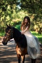 Beautiful girl sits on horseback in a smart dress Royalty Free Stock Photo