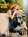 Beautiful girl sits on a lion statue.