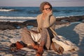 Beautiful girl sitting on the beach in autumn