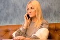 Beautiful girl sitting in the cafe and talking on smart phone