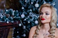 Beautiful girl sitting chair near the fireplace and the Christmas tree. Royalty Free Stock Photo