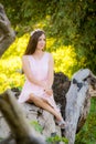 Beautiful girl sitting on fallen tree in the forest Royalty Free Stock Photo
