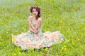 Beautiful girl sitting on the ground near the wall in jeans and a white blouse , her hair develops wind