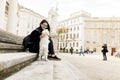 Beautiful girl sitting on stairs with her pet dog after walk in Royalty Free Stock Photo