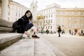 Beautiful girl sitting on stairs with her pet dog after walk in Vienna, Austria Royalty Free Stock Photo