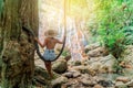 Beautiful Girl sitting at a waterfall in the jungle of Thailand. Exotic tourism in Southeast Asia. Royalty Free Stock Photo