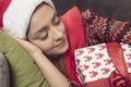 Beautiful girl sleeping on the couch, a gift in her hands, close up Royalty Free Stock Photo