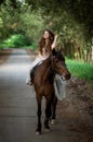beautiful girl in a smart dress riding a horse laughing Royalty Free Stock Photo