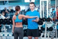 Beautiful girl in sports club with instructor Royalty Free Stock Photo