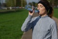 Beautiful girl in sportswear drinks water. Sport fitness woman runner after jogging. Royalty Free Stock Photo