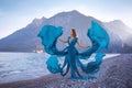 A beautiful girl standing on the beach in a long flying blue dress Royalty Free Stock Photo