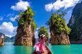 Beautiful girl standing on the boat and looking to mountains in Ratchaprapha Dam Royalty Free Stock Photo