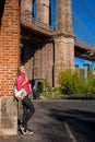 Beautiful girl standing in the Brooklyn Bridge park with a Brooklyn Bridge Royalty Free Stock Photo