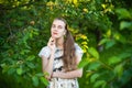 Beautiful girl is standing near the green tree Royalty Free Stock Photo