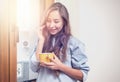 Happy girl standing at window in the morning drinking coffee Royalty Free Stock Photo